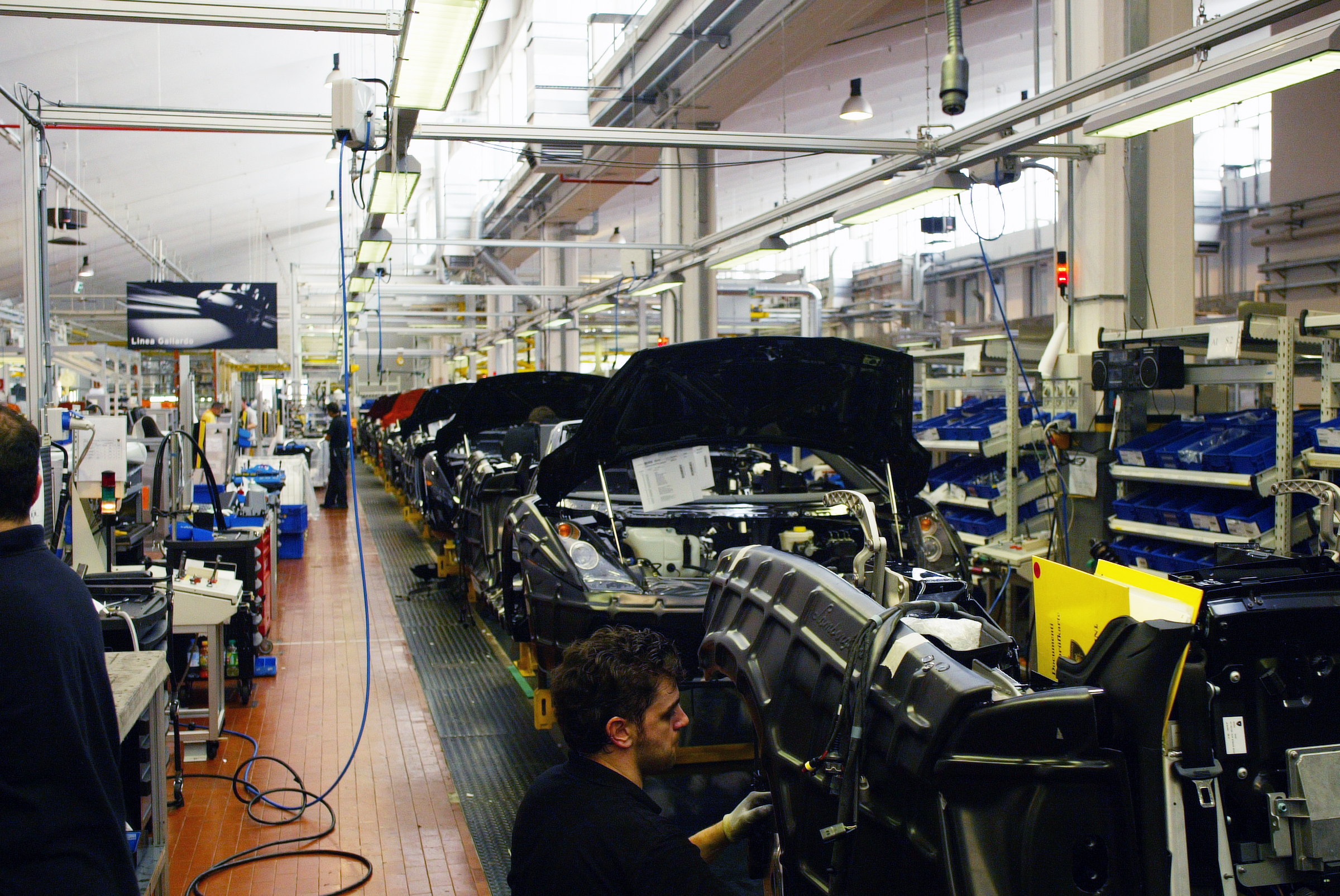 "Lamborghini Gallardo assembly line, 2006 — part of our inauguration tour, where guests could freely wander among the cars and the craftsmen bringing them to life." ©photoLeonBeenen